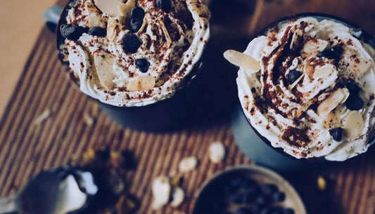 hot chocolate with whipped cream and almonds in enamel mugs